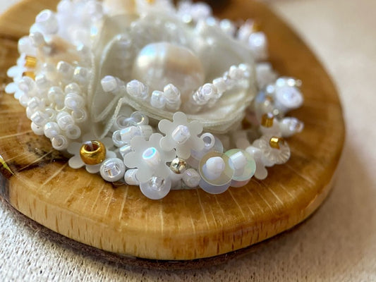 Exclusive wooden pendant with textile and beaded floral center crafted in various hues of white