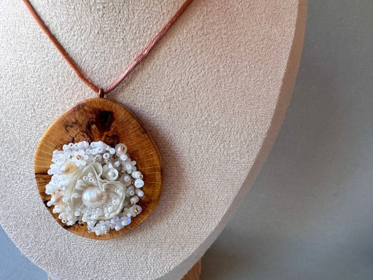 Exclusive wooden pendant with textile and beaded floral center crafted in various hues of white