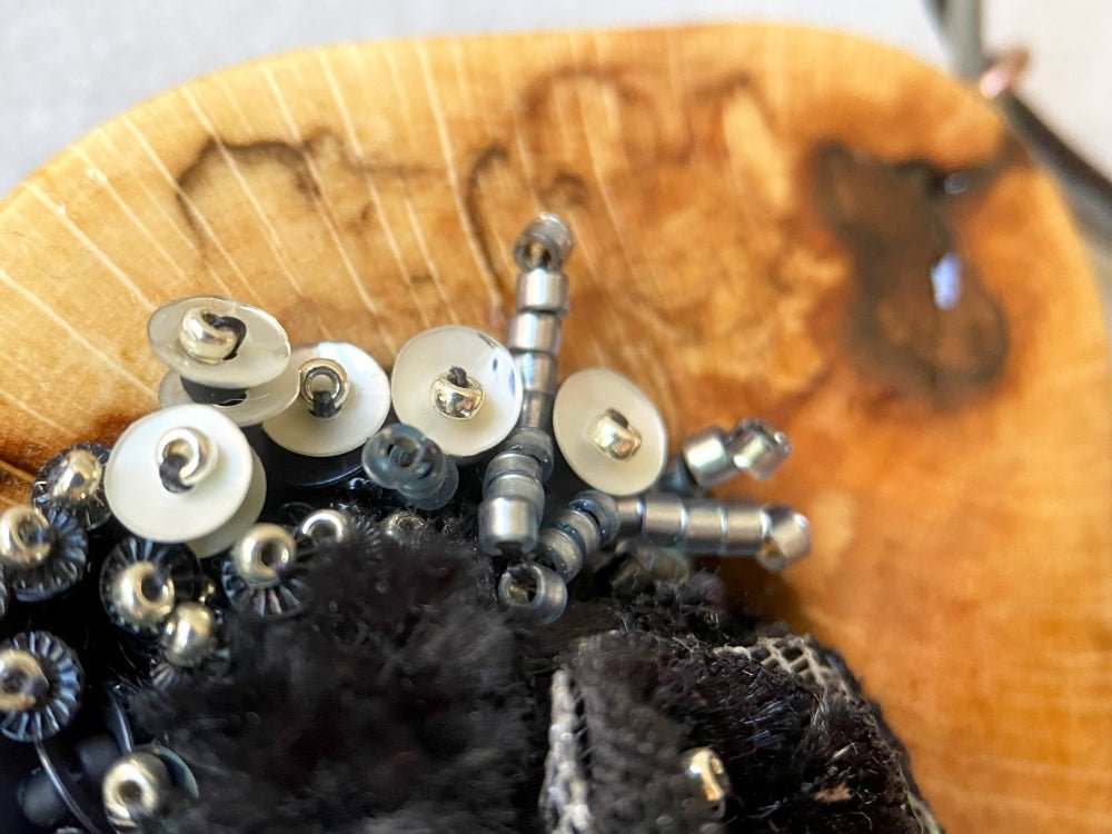 Exclusive wooden pendant with textile and volume-beaded floral inlay crafted in elegant black