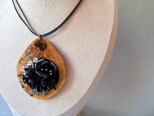 Exclusive wooden pendant with textile and volume-beaded floral inlay crafted in elegant black