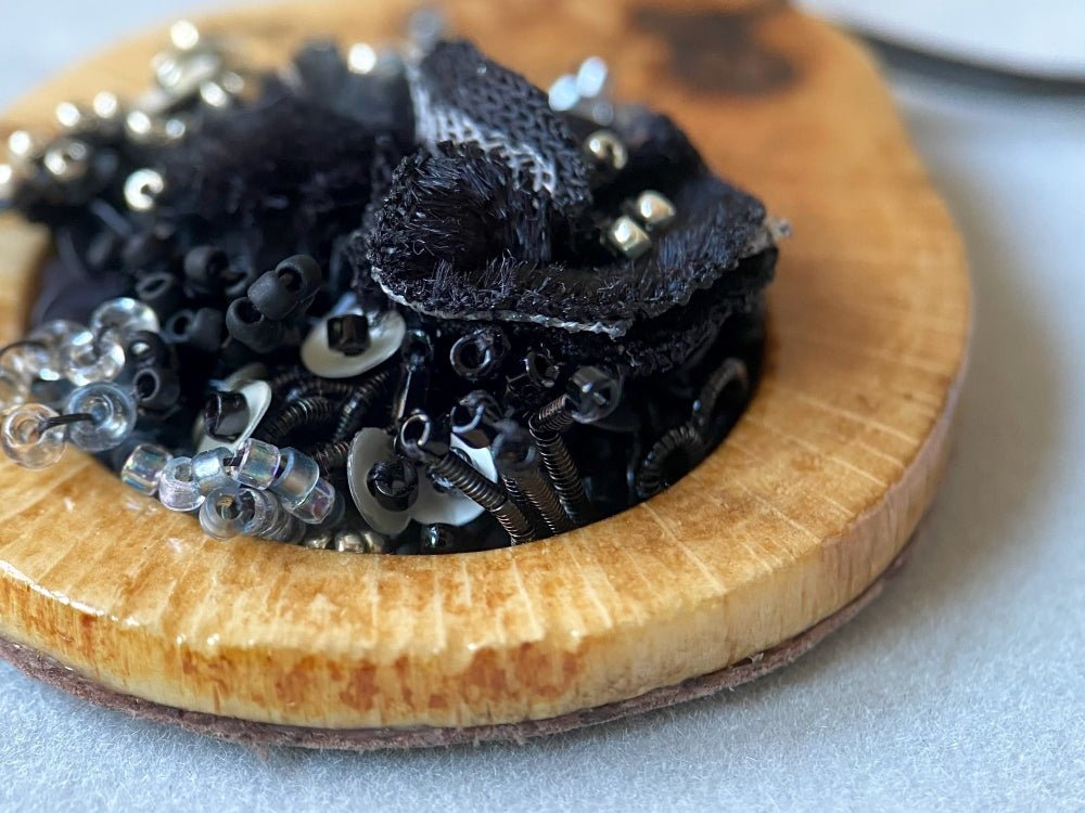 Exclusive wooden pendant with textile and volume-beaded floral inlay crafted in elegant black