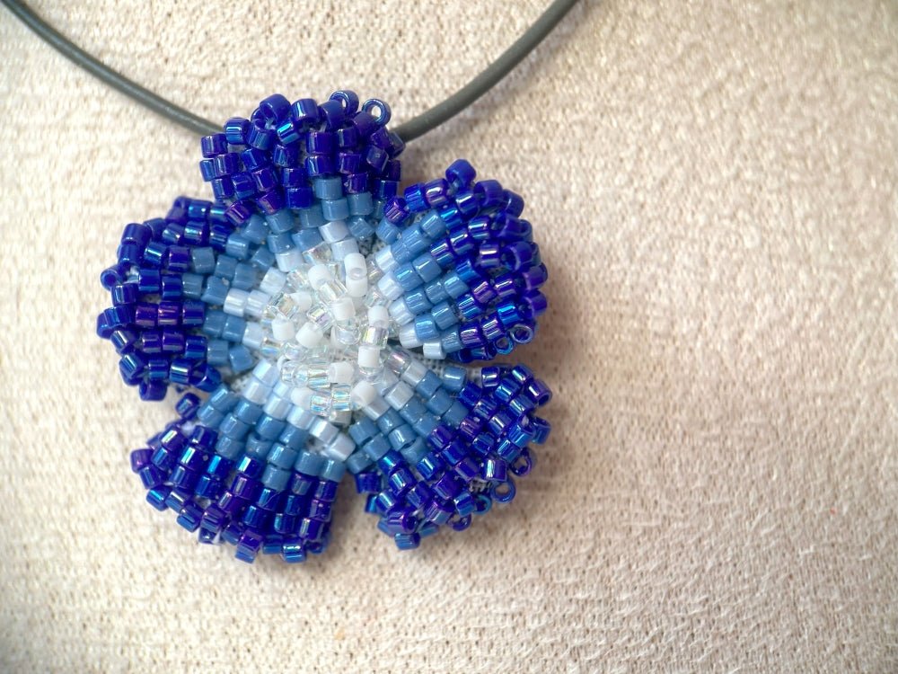 Handmade 360° beaded pendant inspired by blue clematis. Indigo to crystal tones, with leather cord - Ornamentico shop