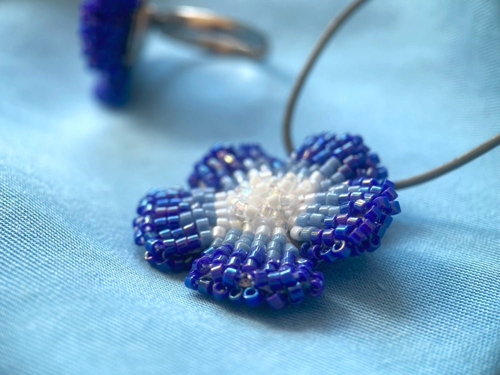 Handmade 360° blue beaded pendant inspired by blue clematis. Indigo to crystal tones, with leather cord - Ornamentico shop