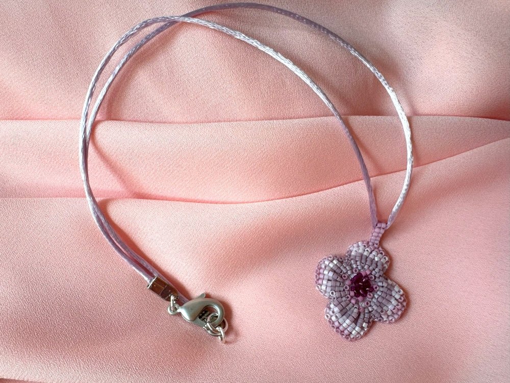 Sculptural floral pendant in soft pink to burgundy tones. Hand-beaded rosette design with silk cord - Ornamentico shop