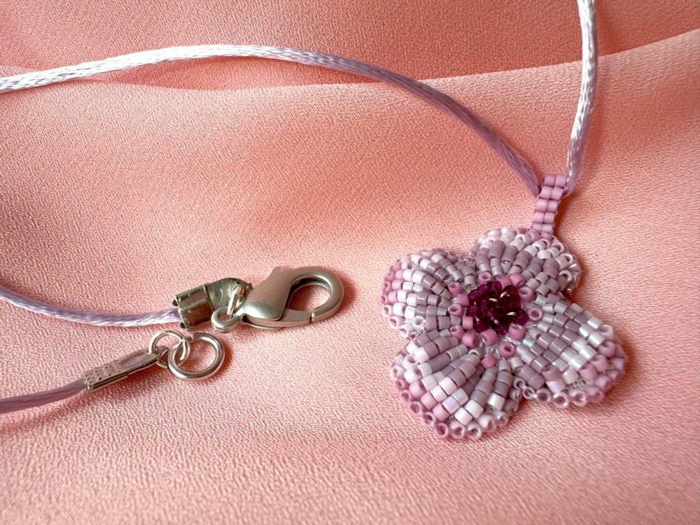 Sculptural floral pendant in soft pink to burgundy tones. Hand-beaded rosette design with silk cord - Ornamentico shop