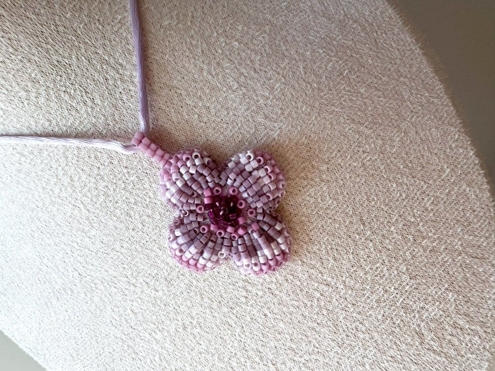 Sculptural floral pendant in soft pink to burgundy tones. Hand-beaded rosette design with silk cord - Ornamentico shop