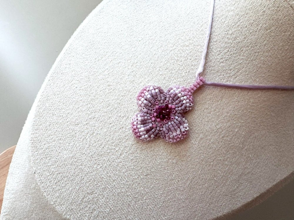 Sculptural floral pendant in soft pink to burgundy tones. Hand-beaded rosette design with silk cord - Ornamentico shop