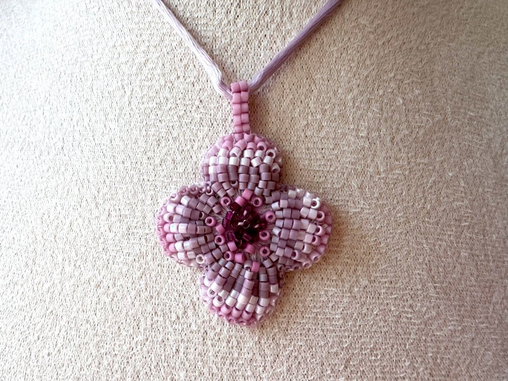 Sculptural floral pendant in soft pink to burgundy tones. Hand-beaded rosette design with silk cord - Ornamentico shop