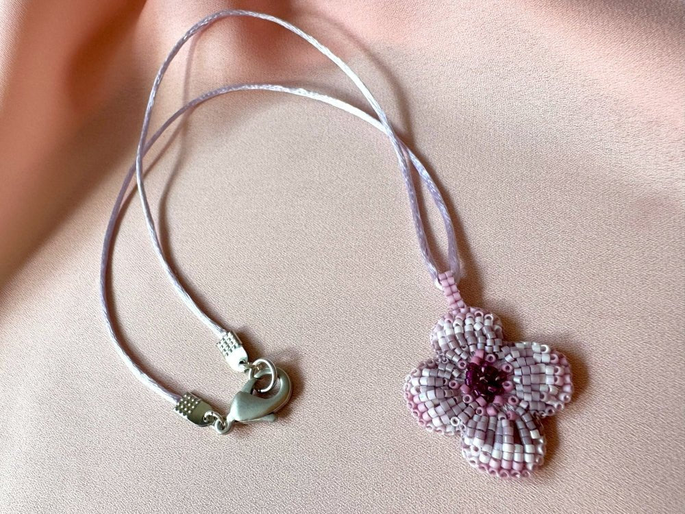Sculptural floral pendant in soft pink to burgundy tones. Hand-beaded rosette design with silk cord - Ornamentico shop