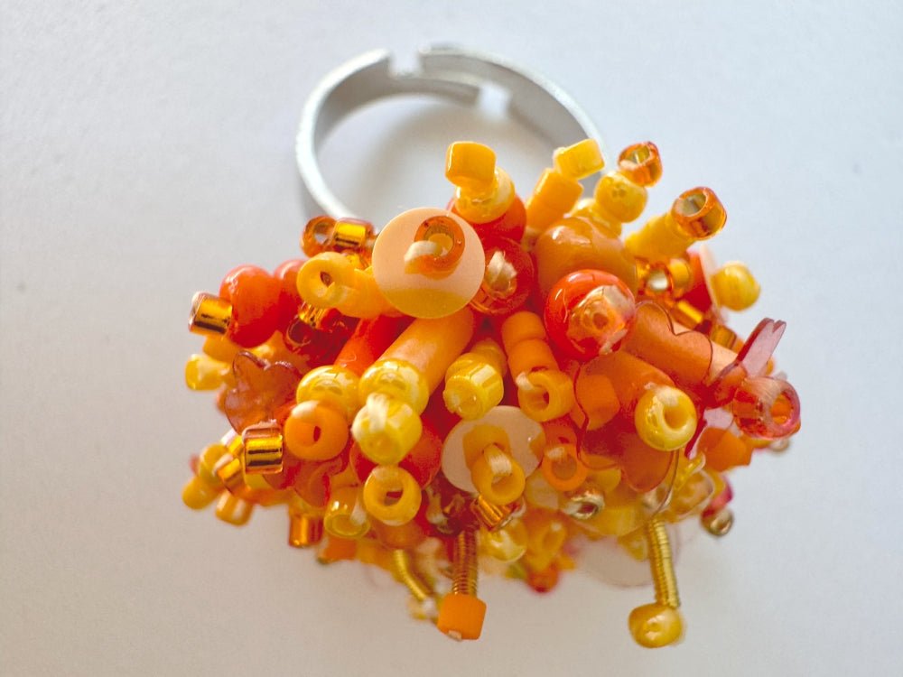 Colorful ring crafted in volume-beading technique from bright orange beads and sequins imitating a blossoming flowerbed - Ornamentico