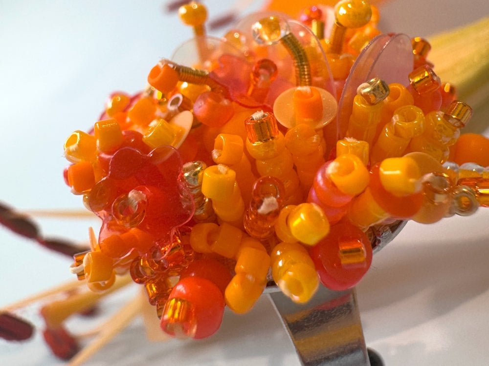 Colorful ring crafted in volume-beading technique from bright orange beads and sequins imitating a blossoming flowerbed - Ornamentico