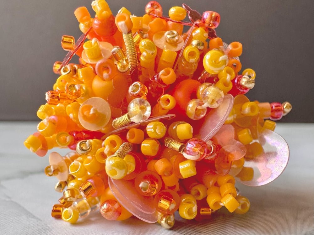 Colorful ring crafted in volume-beading technique from bright orange beads and sequins imitating a blossoming flowerbed - Ornamentico