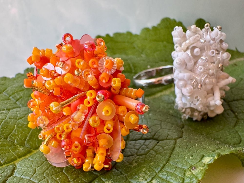 Colorful ring crafted in volume-beading technique from bright orange beads and sequins imitating a blossoming flowerbed - Ornamentico