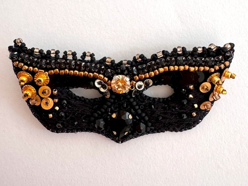 Handmade brooch in the shape of a Venetian masquerade mask crafted in black and gold from beads, sequins, rhinestones and embroidery - Ornamentico Shop