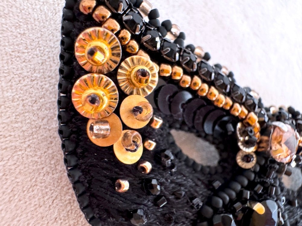 Handmade brooch in the shape of a Venetian masquerade mask crafted in black and gold from beads, sequins, rhinestones and embroidery - Ornamentico Shop