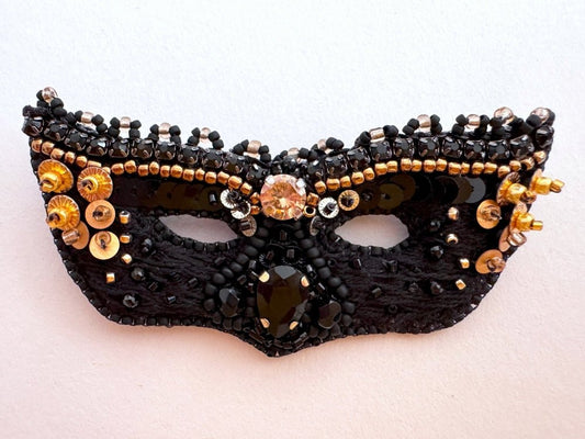 Handmade brooch in the shape of a Venetian masquerade mask crafted in black and gold from beads, sequins, rhinestones and embroidery - Ornamentico Shop