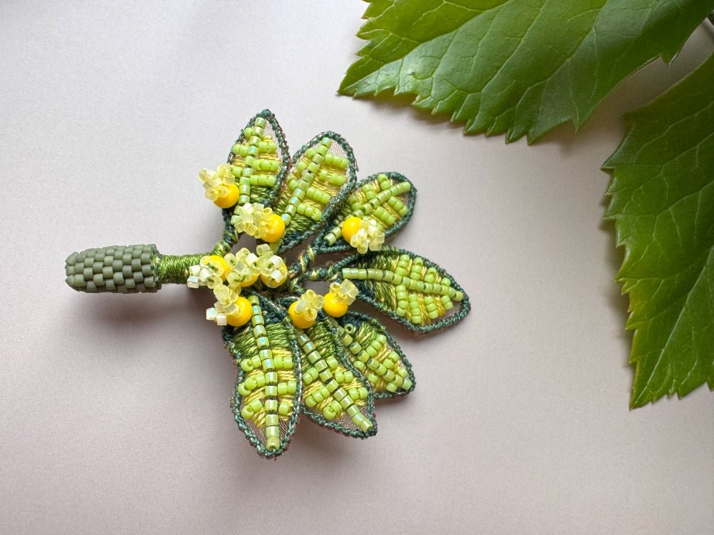 Handmade beaded and embroidered brooch with beaded leaves and yellow mimosa-inspired flowers - Ornamentico shop