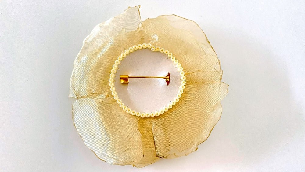 Handmade pale-yellow floral brooch crafted from organza fabric, beads and sequins