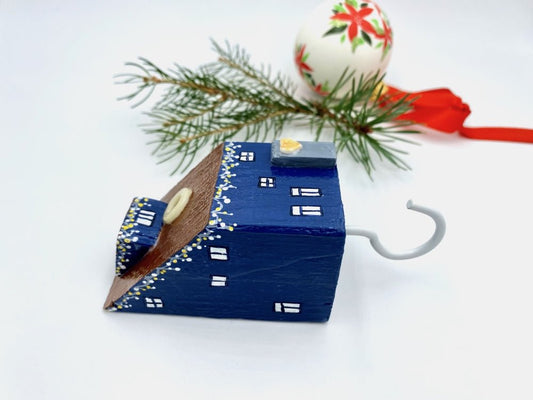 Handmade wall-mounted wooden hook in the shape of indigo blue house decorated with festive garland - Ornamentico shop