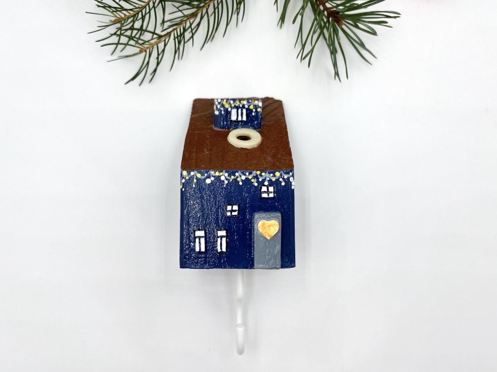Handmade wall-mounted wooden hook in the shape of indigo blue house decorated with festive garland - Ornamentico shop