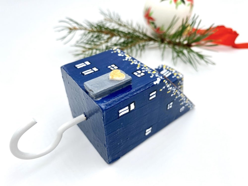 Handmade wall-mounted wooden hook in the shape of indigo blue house decorated with festive garland - Ornamentico shop