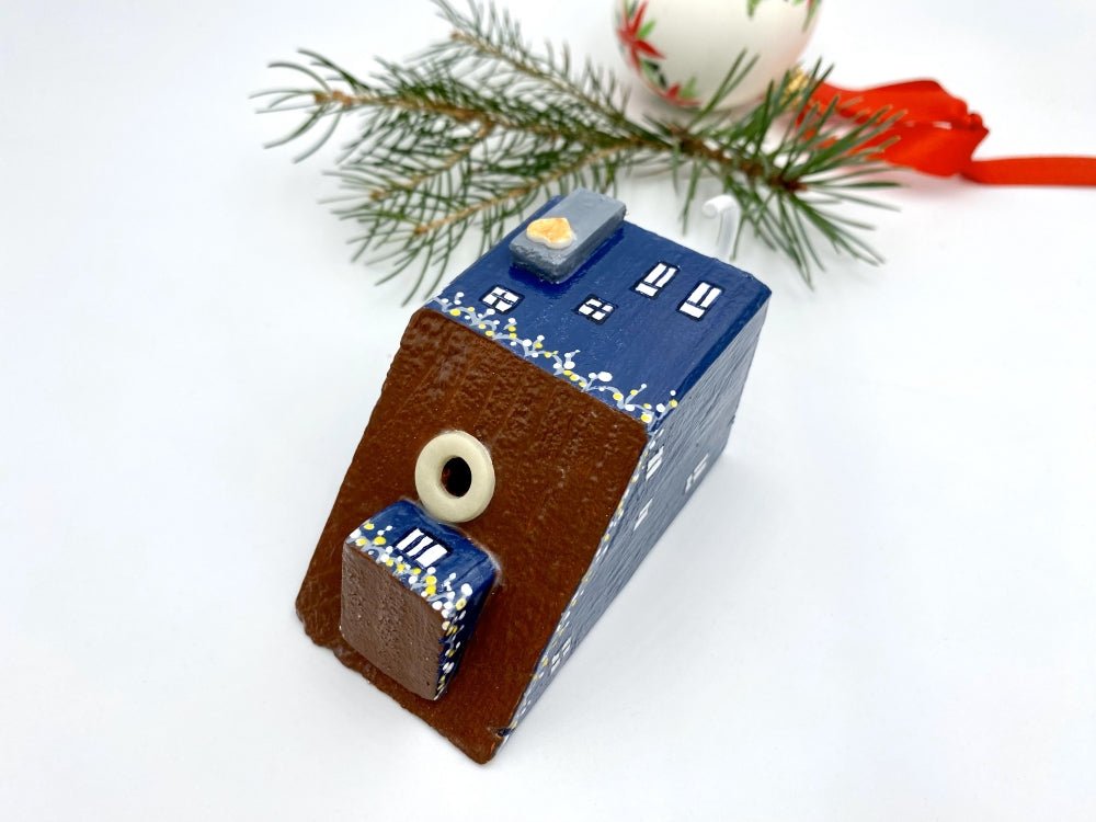 Handmade wall-mounted wooden hook in the shape of indigo blue house decorated with festive garland - Ornamentico shop