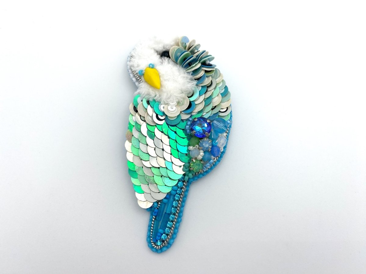 Handmade brooch in the shape of an azure blue wavy parrot made from beads and sequins - Ornamentico shop