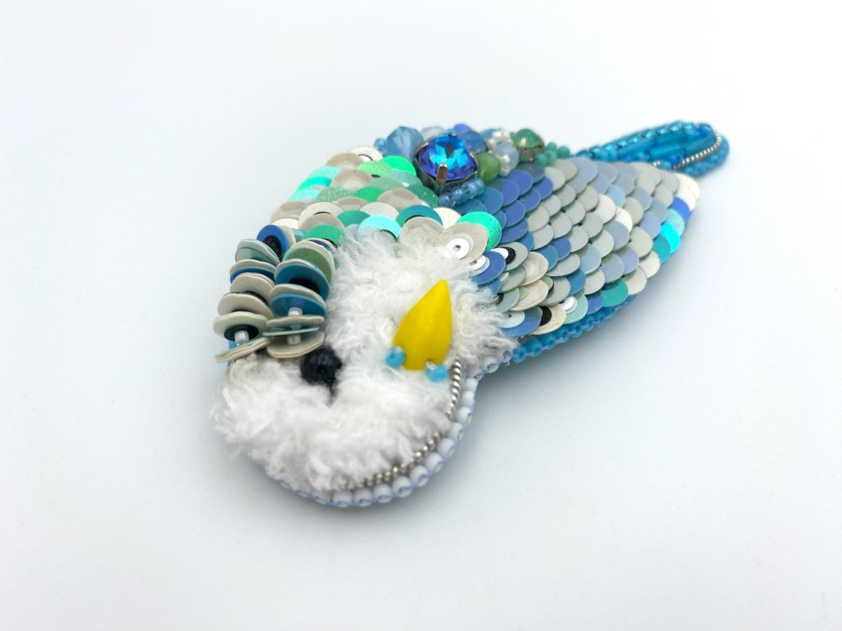 Handmade brooch in the shape of an azure blue wavy parrot made from beads and sequins - Ornamentico shop