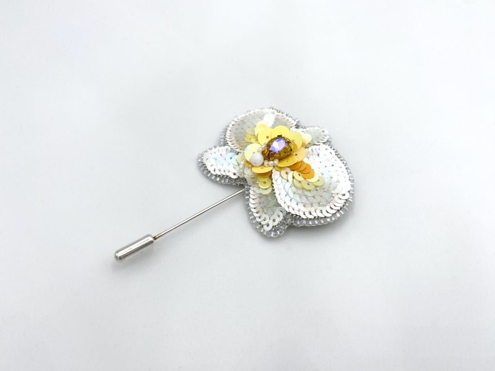 Handmade pin brooch made from rhinestone, sequins and beads in the shape of a small white orchid - Ornamentico shop