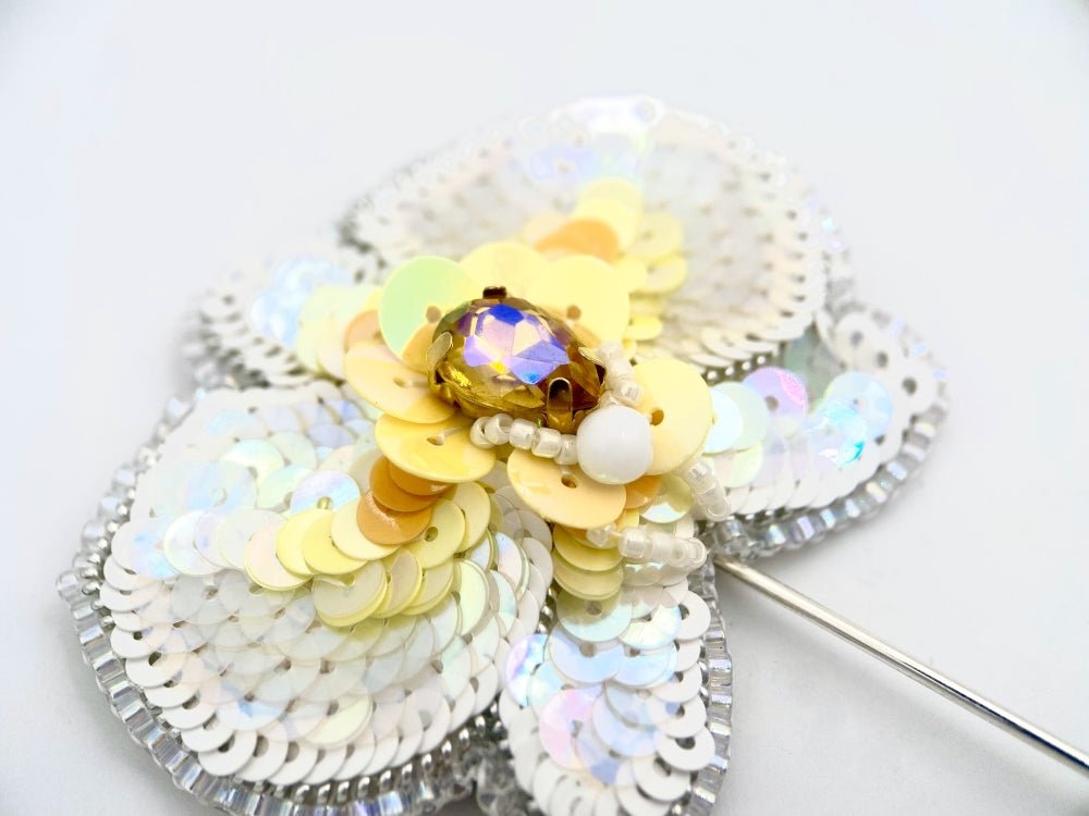 Handmade pin brooch made from rhinestone, sequins and beads in the shape of a small white orchid - Ornamentico shop