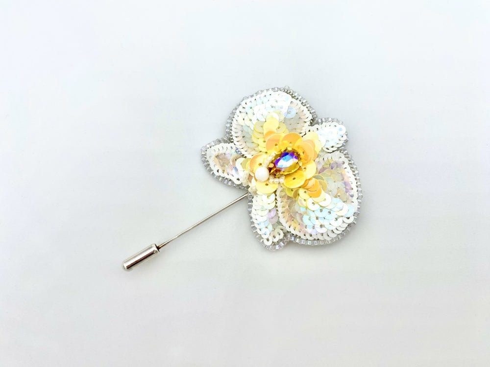 Handmade pin brooch made from rhinestone, sequins and beads in the shape of a small white orchid - Ornamentico shop
