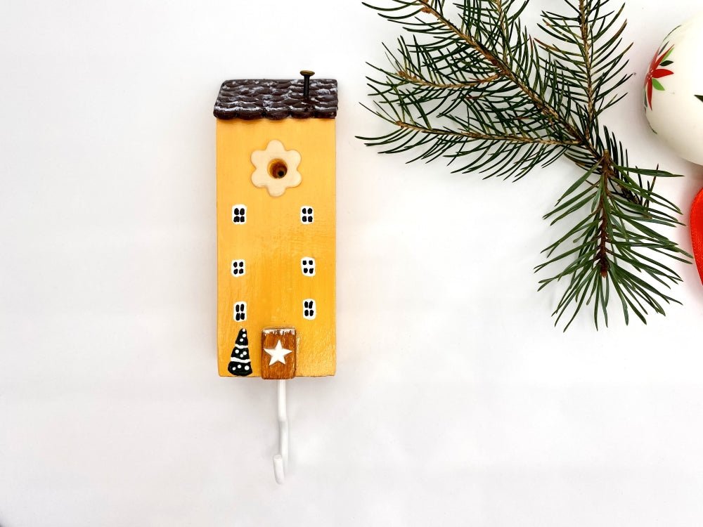 Handmade wooden hook in the shape of a pale orange house decorated for Christmas - Ornamentico shop