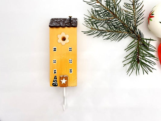 Handmade wooden hook in the shape of a pale orange house decorated for Christmas - Ornamentico shop