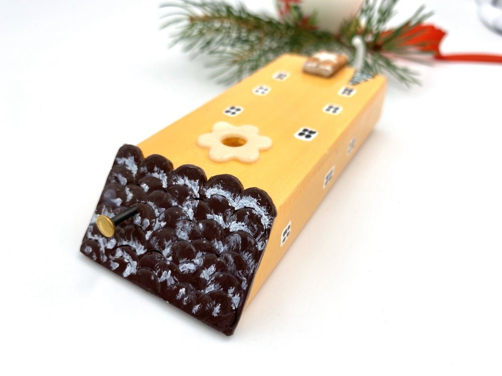 Handmade wooden hook in the shape of a pale orange house decorated for Christmas - Ornamentico shop