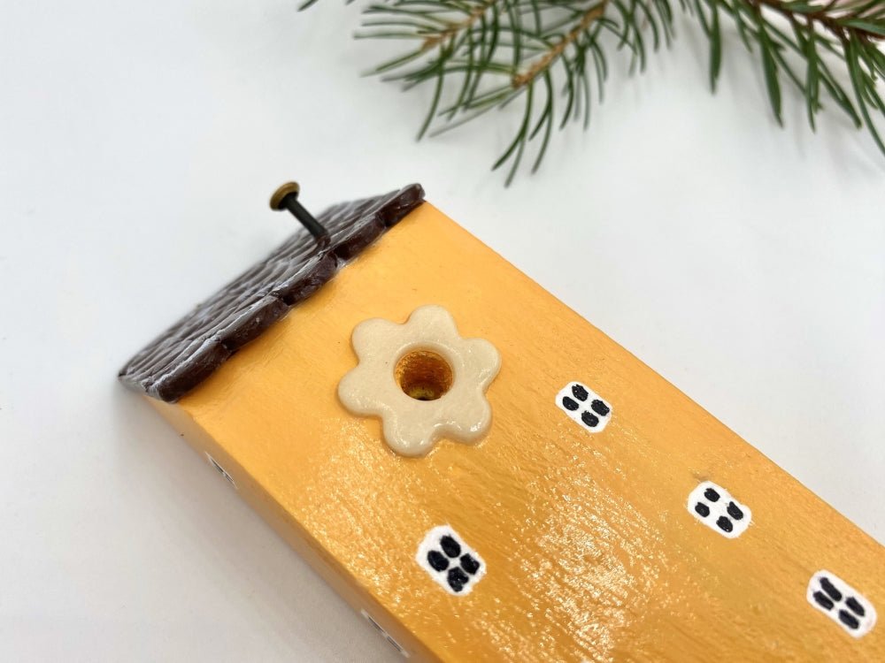 Handmade wooden hook in the shape of a pale orange house decorated for Christmas - Ornamentico shop