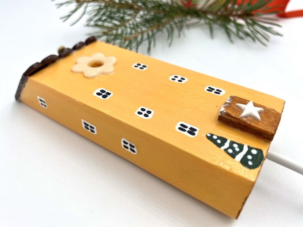 Handmade wooden hook in the shape of a pale orange house decorated for Christmas - Ornamentico shop
