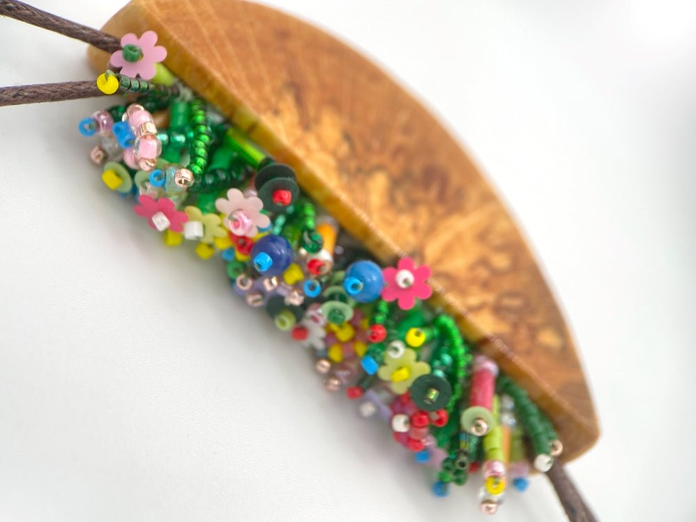 Unique wooden pendant with colorful beaded inlay imitating summer flowerbed