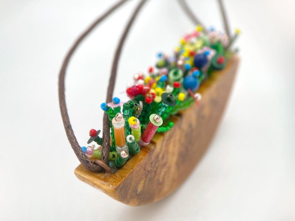 Unique wooden pendant with colorful beaded inlay imitating summer flowerbed