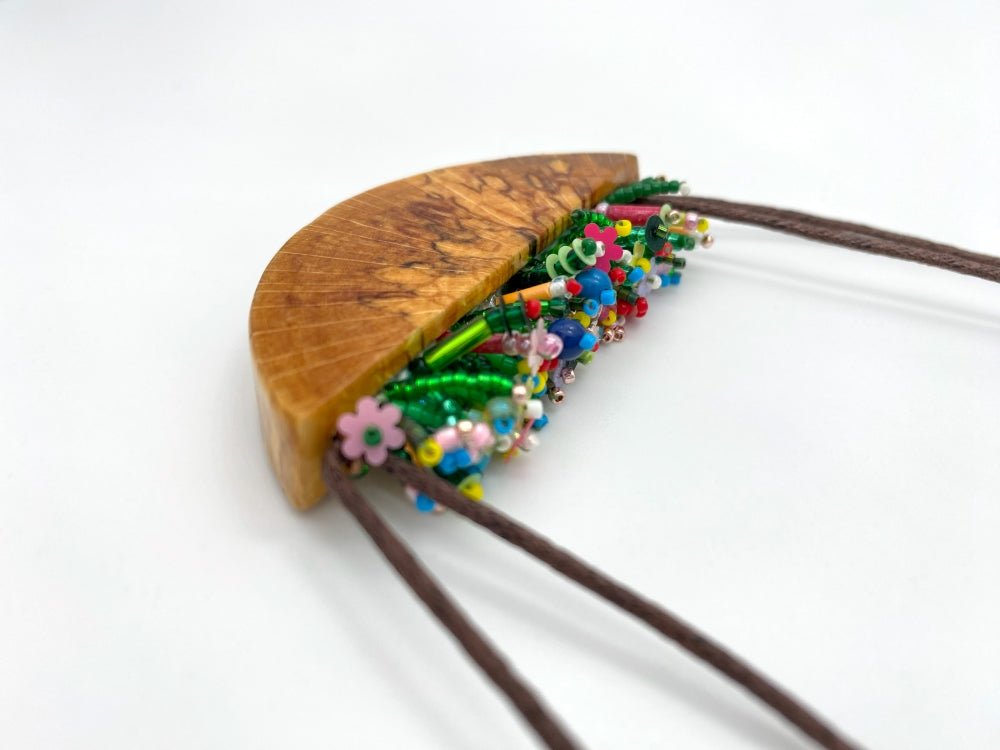 Unique wooden pendant with colorful beaded inlay imitating summer flowerbed