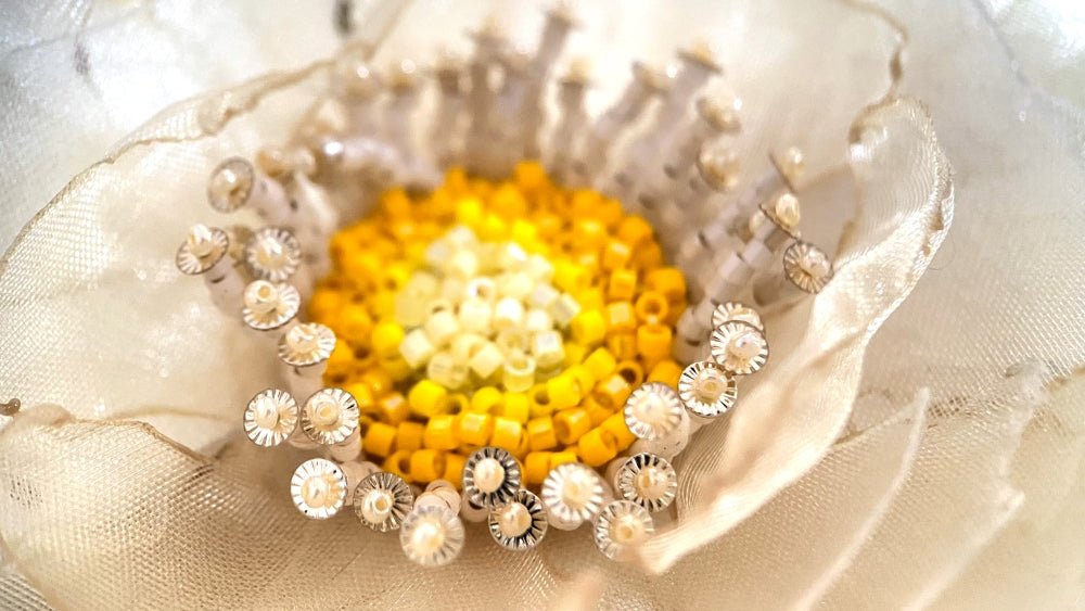 Handmade floral hair barrette crafted from organza fabric and decorated with beaded flower center and stamens