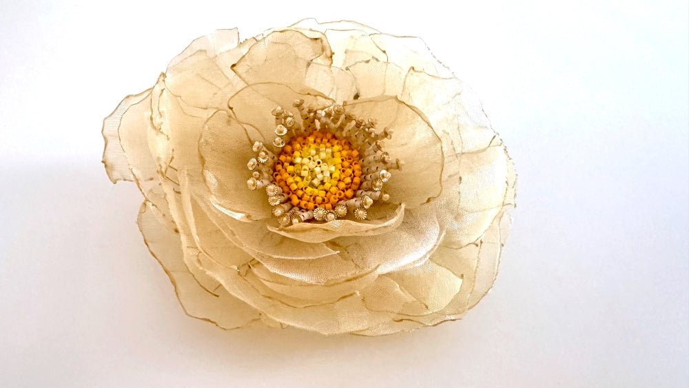 Handmade floral hair barrette crafted from organza fabric and decorated with beaded flower center and stamens