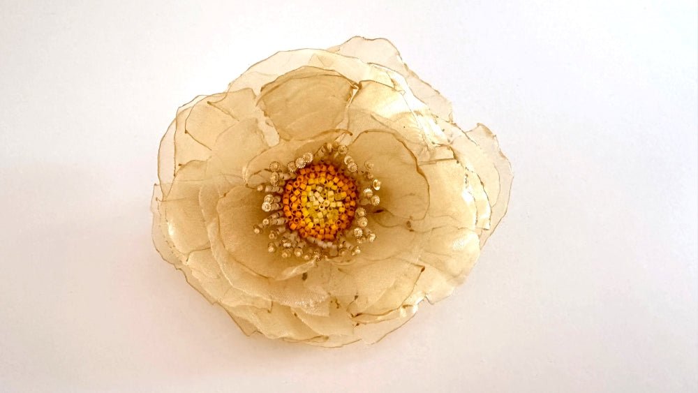 Handmade floral hair barrette crafted from organza fabric and decorated with beaded flower center and stamens