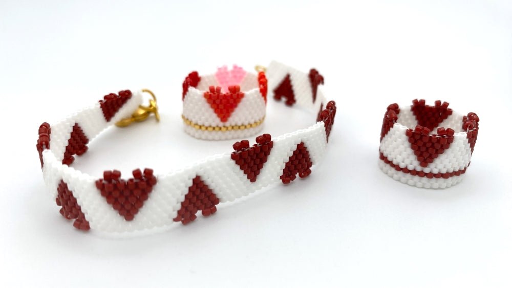 Handmade set of beaded bracelet and two rings ornamented with hearts crafted in peyote stitch technique 