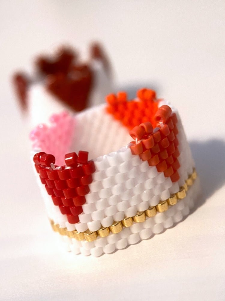 Beaded ring crafted in peyote stitch technique featuring bright hearts standing out from the ring's edge