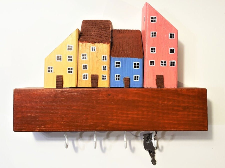 Colorful hand painted wooden key hanger decorated with wooden houses. Wall-mounted design.