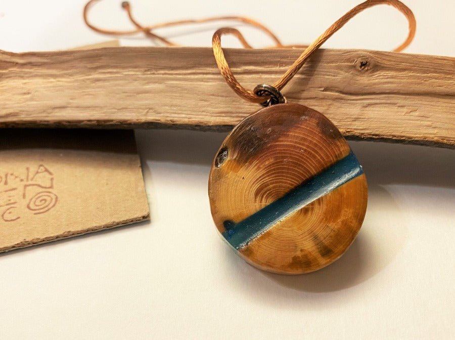 Handmade wooden pendant. Made of polished and lacquered beech with sea colored epoxy inlay