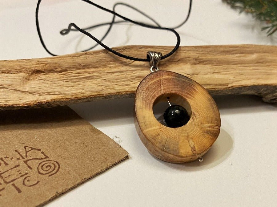 Small handmade wooden pendant with an obsidian bead. 