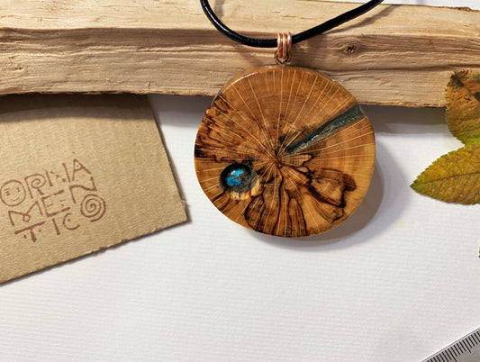 Handmade wooden pendant. Made of polished and lacquered beech wood. Sea-colored epoxy resin inlay with one shattuckite stone.