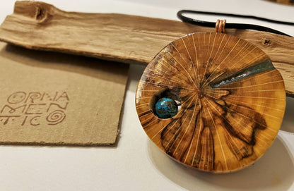 Handmade wooden pendant. Made of polished and lacquered beech wood. Sea-colored epoxy resin inlay with one shattuckite stone.