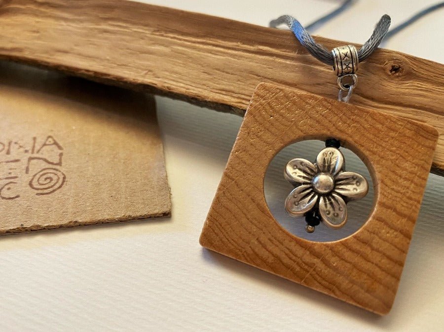 Square wooden pendant with silver inlay in the shape of a flower. Beech, silver.